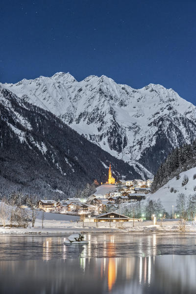 Muehlwald, Bolzano district, South Tyrol, Italy, Europe. The village of Muehlwald is reflected in the Meggima lake