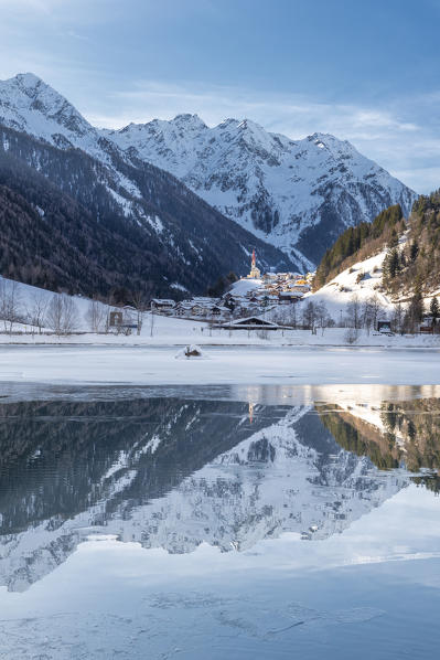 Muehlwald, Bolzano district, South Tyrol, Italy, Europe. The village of Muehlwald is reflected in the Meggima lake