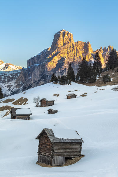 Corvara, Alta Badia, province of Bolzano, South Tyrol, Italy, Europe. Barns in the pastures Pra d'Inzija with the Mount Sassongher in the background