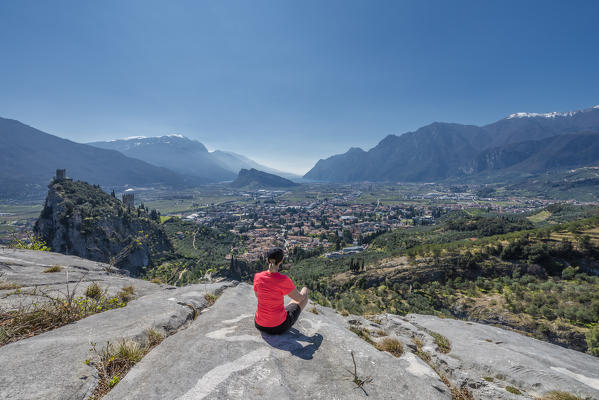 Arco, Trento province, Trentino, Italy, Europe. A Woman admires the panorama of the mountain Colodri, the view extends over the city of Arco to the Lake Garda