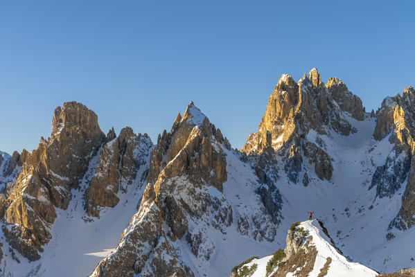 Mount Campedelle, Misurina, Auronzo di Cadore, province of Belluno, Veneto, Italy, Europe. A mountaineer admires the sunrise in the Cadini di Misurina mountains