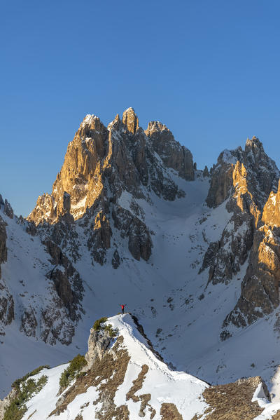 Mount Campedelle, Misurina, Auronzo di Cadore, province of Belluno, Veneto, Italy, Europe. A mountaineer admires the sunrise in the Cadini di Misurina mountains