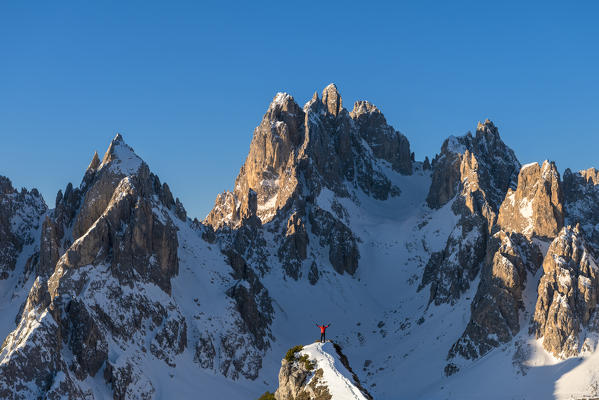 Mount Campedelle, Misurina, Auronzo di Cadore, province of Belluno, Veneto, Italy, Europe. A mountaineer admires the sunrise in the Cadini di Misurina mountains