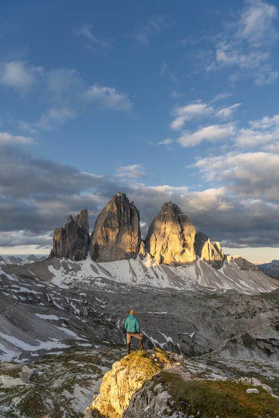 Sesto / Sexten, province of Bolzano, Dolomites, South Tyrol, Italy. A mountaineer admires the panorama at sunrise