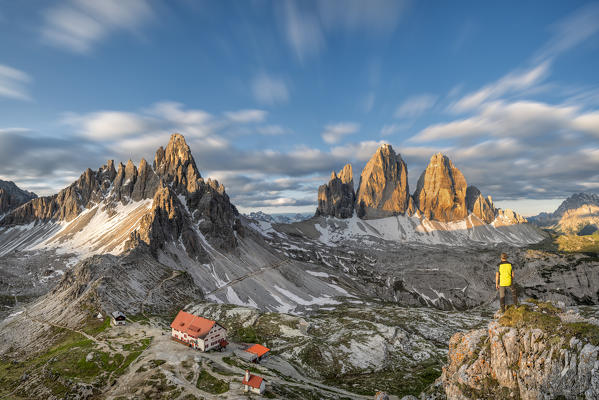 Sesto / Sexten, province of Bolzano, Dolomites, South Tyrol, Italy. A mountaineer admires the panorama at sunrise (MR)