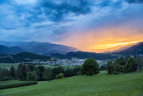 Brunico/ Bruneck, Bolzano province, South Tyrol, Italy. Thunderstorm and sunset over the city of Bruneck