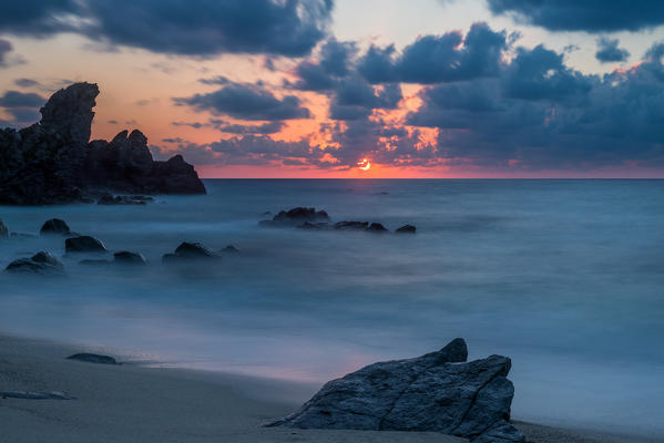 Zambrone, Calabria, Italy. Sunset on the beach of Capo Cozzo in Calabria with the Lion Rock