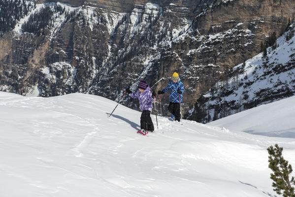 Fanes, Dolomites, South Tyrol, Italy. Children wearing snowshoes walking in the mountains of the Fanes