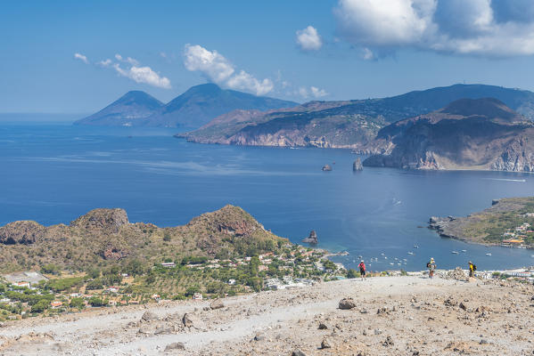 Volcano, Messina district, Sicily, Italy, Europe. Hikers on the crater of Vulcano. In the background the isöands Lipari and Salina