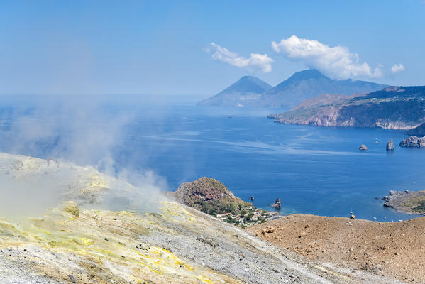 Volcano, Messina district, Sicily, Italy, Europe. Sulfur fumaroles on the crater rim of Vulcano. In the background the islands of Lipari and Salina