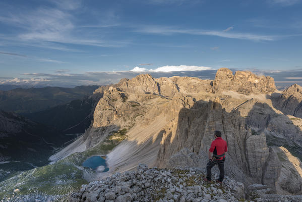 Sesto / Sexten, province of Bolzano, Dolomites, South Tyrol, Italy. A mountaineer admires the alpenglow at the summit of Mount Paterno