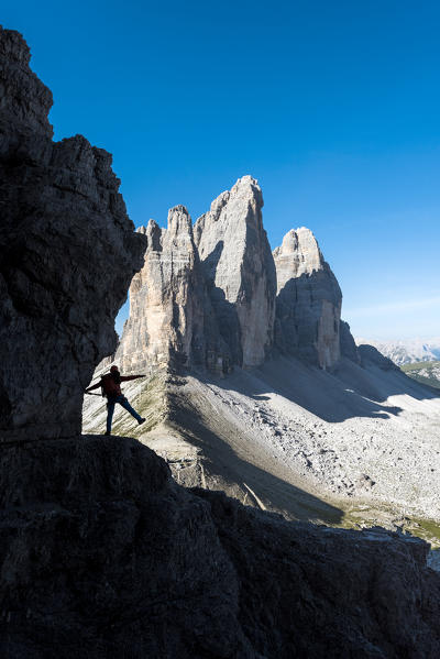 Sesto / Sexten, province of Bolzano, Dolomites, South Tyrol, Italy. Silhouette of a mountaineer in front of the Three Peaks of Lavaredo