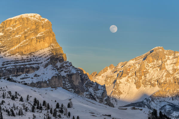 Gardena Pass, Alta Badia, province of Bolzano, South Tyrol, Italy, Europe. While the rocks of the Sassongher and Lavarella glow in the sunset, the full moon rises