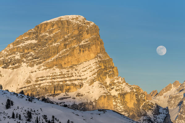 Gardena Pass, Alta Badia, province of Bolzano, South Tyrol, Italy, Europe. While the rocks of the Sassongher glow in the sunset, the full moon rises