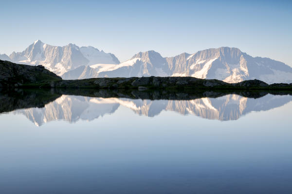 Presanella group in the mirror, dawn from the lakes of Strino, Val di Sole, Trentino Alto Adige, Italy