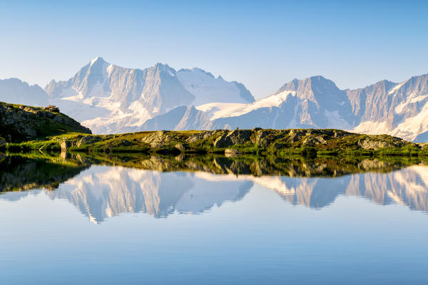 Presanella group in the mirror, dawn from the lakes of Strino, Val di Sole, Trentino Alto Adige, Italy