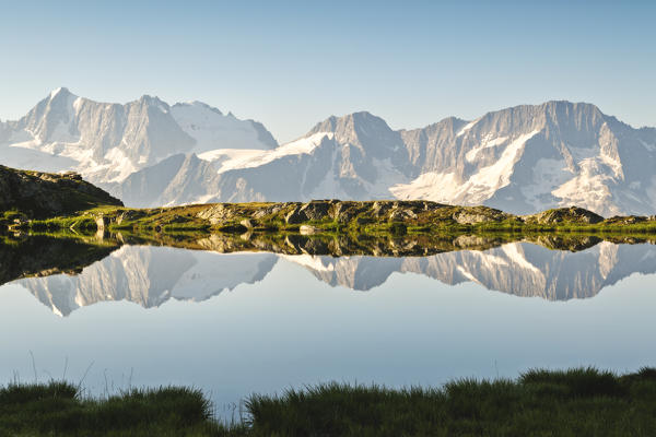 Presanella group in the mirror, dawn from the lakes of Strino, Val di Sole, Trentino Alto Adige, Italy