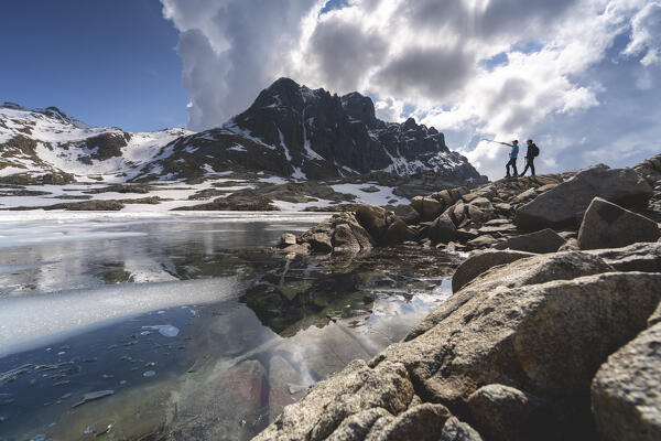 Hikers near the alpine lakes, lago della Vacca in Vallecamonica, Brescia province in Lombardy district, Italy.