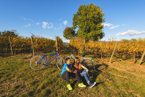 Couple of Bikers in Vineyards, Franciacorta, Province of Brescia, Lombardy, Italy.