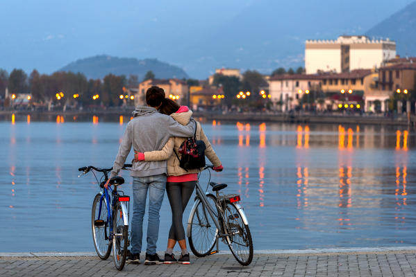 Pair of cyclists at sunset, iseo lake, Brescia province, Lombardy district, Italy.