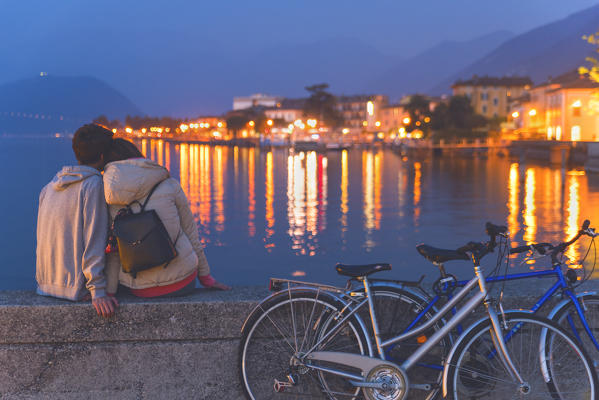 Pair of cyclists at sunset, iseo lake, Brescia province, Lombardy district, Italy.