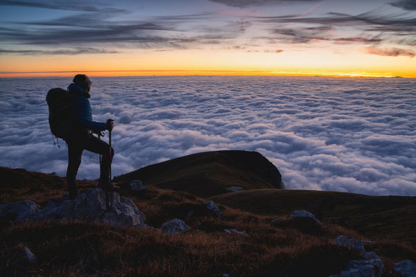 Trekker at Sunset from Mount Guglielmo above the Clouds, Brescia province, Lombardy district, Italy