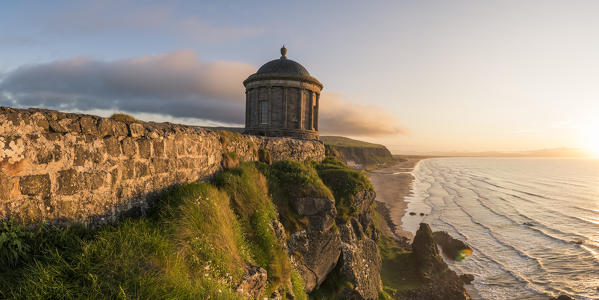 Mussenden temple, Castlerock, County Antrim, Ulster region, northern Ireland, United Kingdom. Panoramic view of the temple and the coast at sunset.