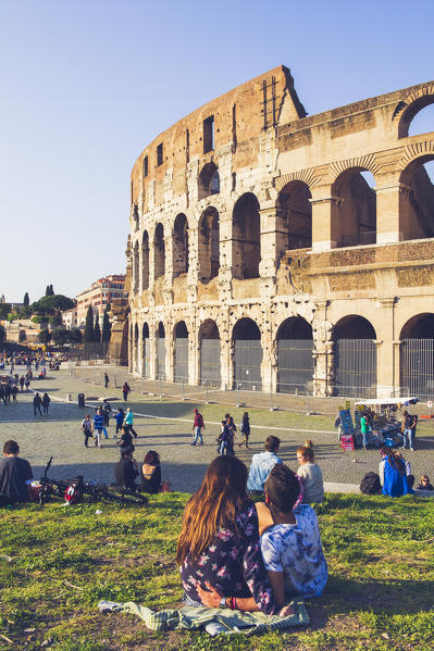 Rome, Lazio, Italy. Couple looks at the coliseum from the meadow.