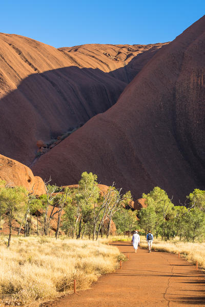 Uluru (Ayers Rock), Uluru-Kata Tjuta National Park, Northern Territory, Central Australia, Australia. Two people walking along the Mutitjulu Waterhole trail.