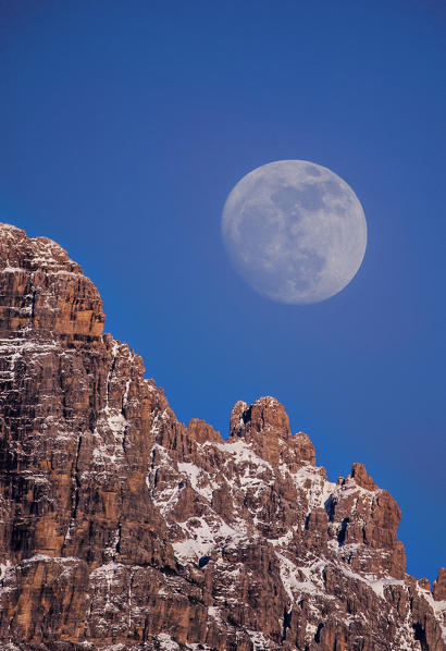 Cridola Mount, Dolomites, Veneto, Italy. The Moon rises from rocks