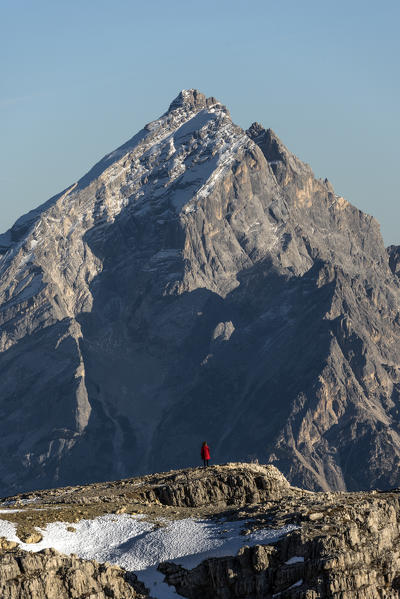 Antelao mount, Dolomiti, Dolomites, Belluno, Veneto, Italy. Hiker in red looking at Antealo