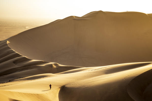 Man walking on the sand dunes at sunset,Walvis Bay,Namibia,Africa