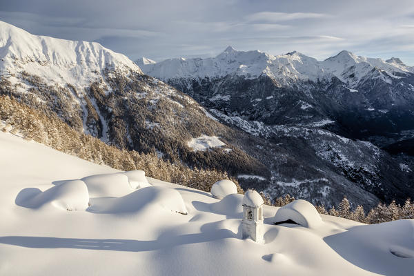 Italy, Italian Alps, Lombardy, The huts and the bell tower of Alpe Cima sorrounded by metres of snow