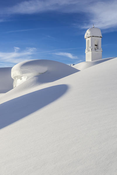 Italy, Italian Alps, Lombardy, The huts and the bell tower of Alpe Cima sorrounded by metres of snow