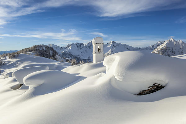 Italy, Italian Alps, Lombardy, The huts and the bell tower of Alpe Cima sorrounded by metres of snow