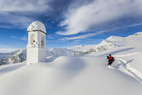 Italy, Italian Alps, Lombardy, The huts and the bell tower of Alpe Cima sorrounded by metres of snow