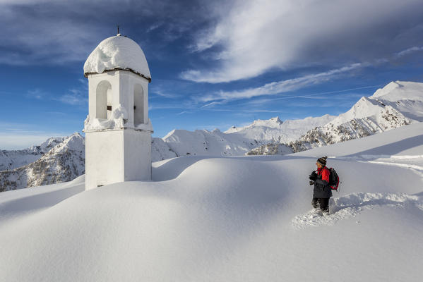 Italy, Italian Alps, Lombardy, The huts and the bell tower of Alpe Cima sorrounded by metres of snow