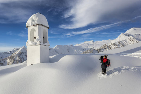 Italy, Italian Alps, Lombardy, The huts and the bell tower of Alpe Cima sorrounded by metres of snow