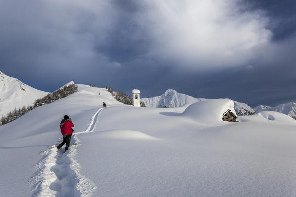 Italy, Italian Alps, Lombardy, The huts and the bell tower of Alpe Cima sorrounded by metres of snow