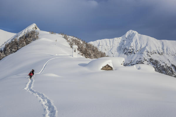 Italy, Italian Alps, Lombardy, The huts and the bell tower of Alpe Cima sorrounded by metres of snow