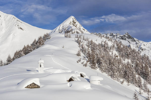 Italy, Italian Alps, Lombardy, The huts and the bell tower of Alpe Cima sorrounded by metres of snow