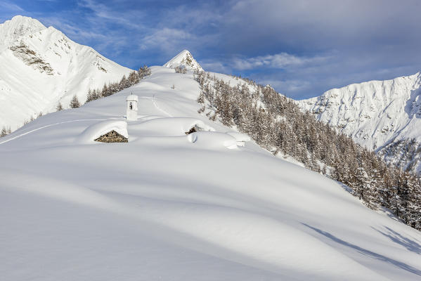 Italy, Italian Alps, Lombardy, The huts and the bell tower of Alpe Cima sorrounded by metres of snow