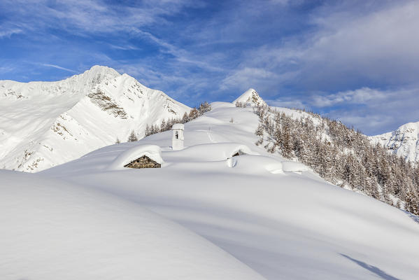 Italy, Italian Alps, Lombardy, The huts and the bell tower of Alpe Cima sorrounded by metres of snow