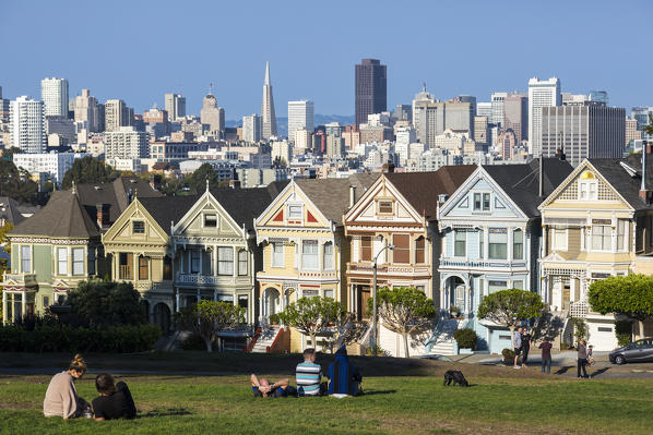 People relaxing in front of the Painted Ladies, the victorian rowhouses in Haight-Ashbury neighborhood. San Francisco, Marin County, California, USA.