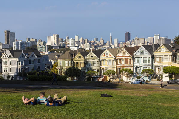 People relaxing in front of the Painted Ladies, the victorian rowhouses in Haight-Ashbury neighborhood. San Francisco, Marin County, California, USA.