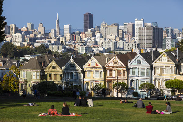 People relaxing in front of the Painted Ladies, the victorian rowhouses in Haight-Ashbury neighborhood. San Francisco, Marin County, California, USA.