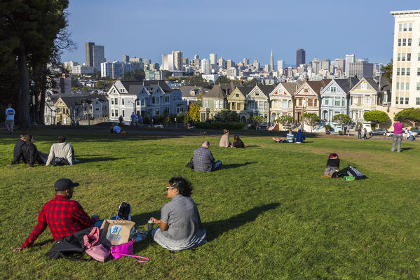 People relaxing in front of the Painted Ladies, the victorian rowhouses in Haight-Ashbury neighborhood. San Francisco, Marin County, California, USA.