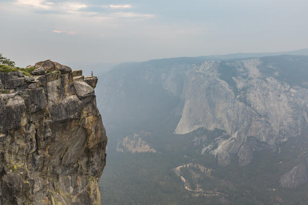 Person on the edge at Taft Point view, Yosemite Valley. Yosemite National Park, Mariposa County, California, USA.