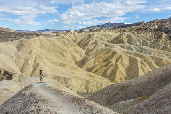 Woman admiring the landscape. Zabriskie Point, Death Valley National Park, Inyo County, California, USA.