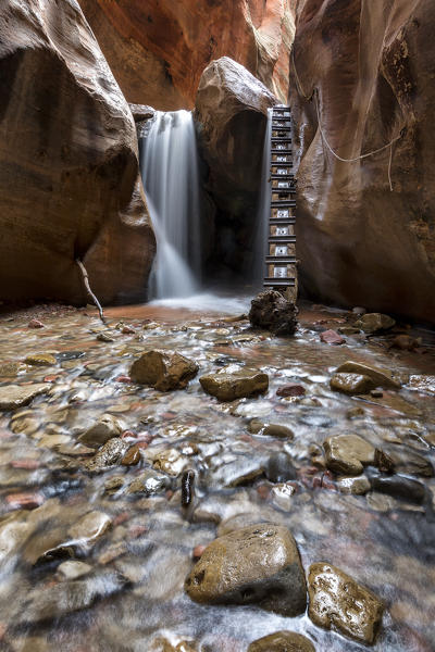 Long exposure at waterfall and ladder in Kanarra Creek Canyon. Kanarraville, Iron County, Utah, USA.